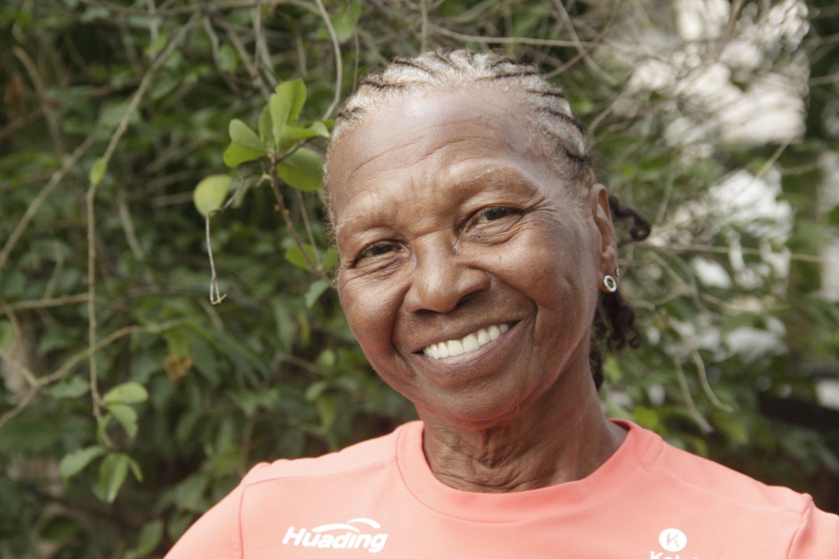 Older woman in a pink shirt smiling