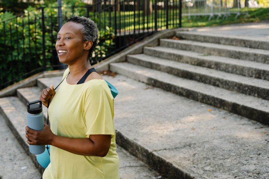 Woman walking outdoors with a water bottle