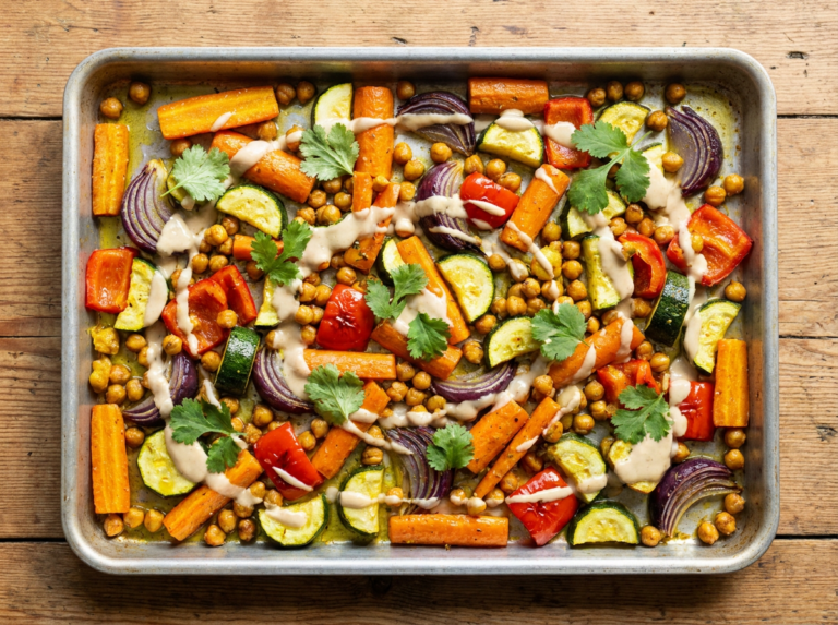 A traybake of turmeric-roasted vegetables and chickpeas with a tahini drizzle